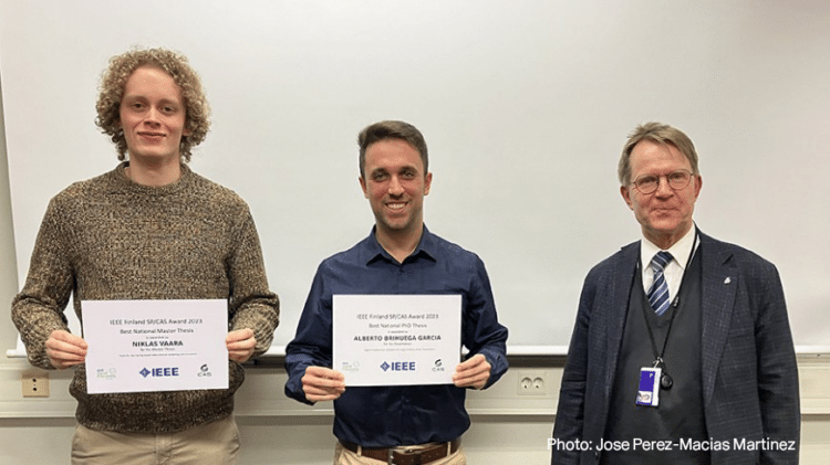 Niklas Vaara and Alberto Rhunha Garcia holding IEEE Finland SP/CAS Awards next to Professor Ari Visa.