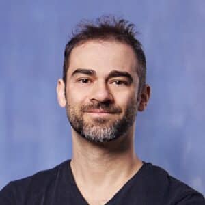 Assistant Professor Italo Atzeni smiling against a blue background