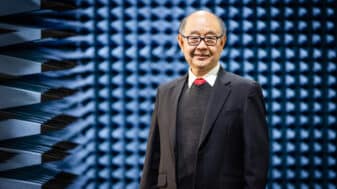 Professor Jay Guo standing in front of anechoic chamber wall