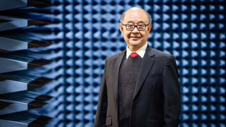 Professor Jay Guo standing in front of anechoic chamber wall
