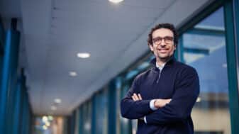 Professor Mehdi Bennis standing in a University of Oulu's corridor with arms crossed