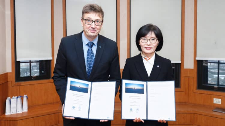 Representatives from the University of Oulu and a South Korean institution holding signed Memorandums of Understanding.