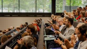 A full lecture hall of attendees applauding at Nordic DigiHealth 2026