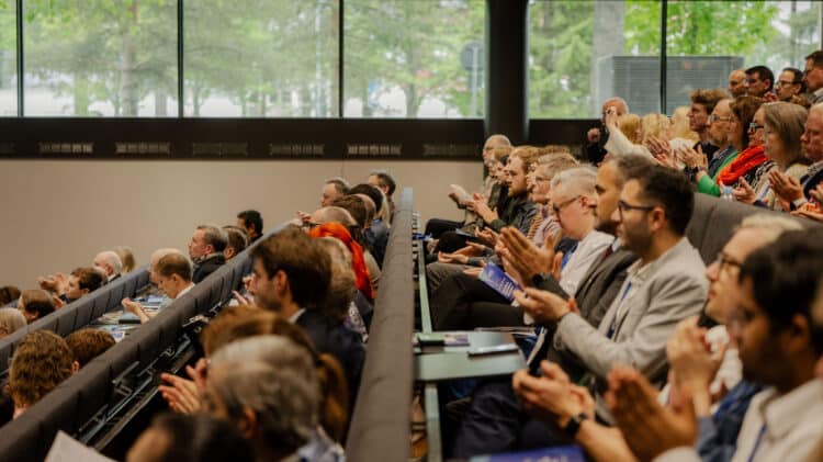 A full lecture hall of attendees applauding at Nordic DigiHealth 2026