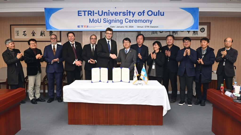 Representatives from the University of Oulu and ETRI shaking hands at the MoU signing ceremony.